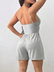 Light gray ruched spaghetti strap romper with a cinched waist and short shorts.