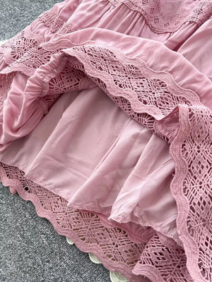 Pink tiered skirt with crochet lace trim and drawstring detail.