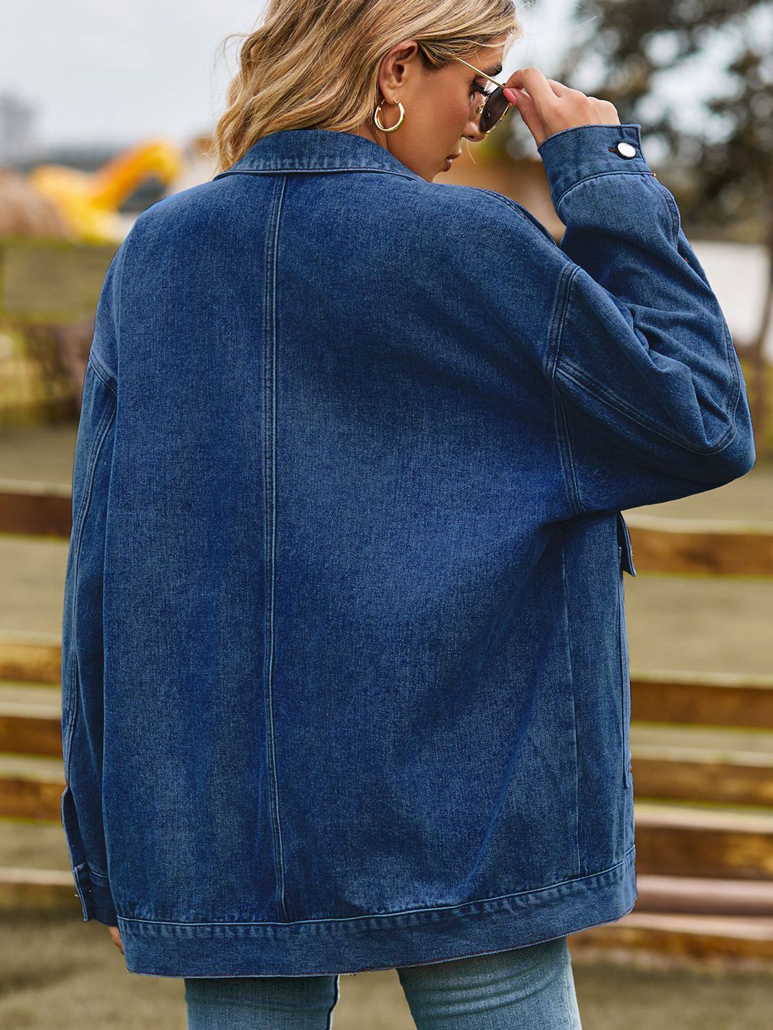 Oversized denim trucker jacket in medium blue wash with collared neckline and button cuffs.