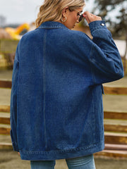 Oversized denim trucker jacket in medium blue wash with collared neckline and button cuffs.
