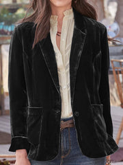 Black velvet blazer with rolled cuff detail and buttoned front, styled with a cream ruffled blouse.