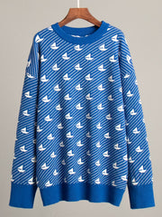 Royal blue knit sweater with white sailboat pattern, crew neck, long sleeves, ribbed cuffs and hem.