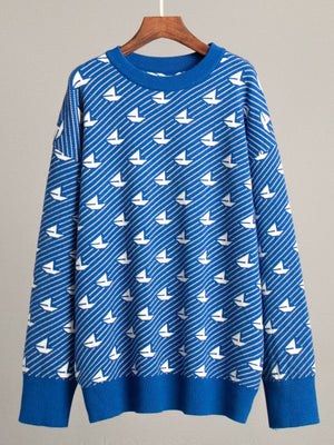 Royal blue knit sweater with white sailboat pattern, crew neck, long sleeves, ribbed cuffs and hem.