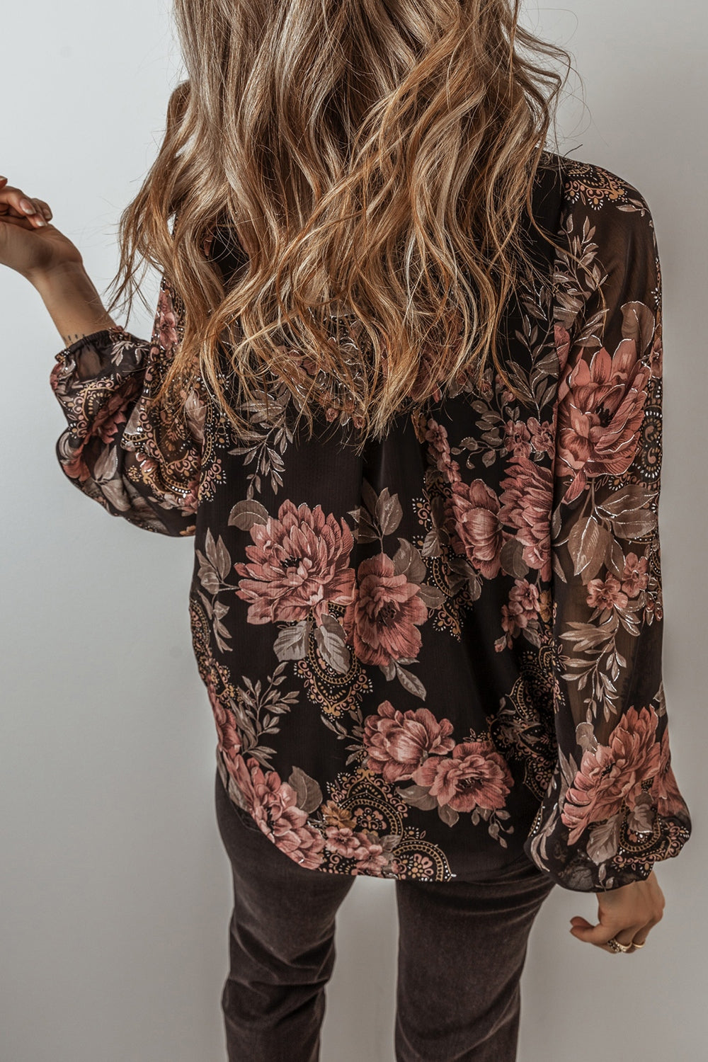 Black floral print blouse with blouson sleeves and sheer fabric.