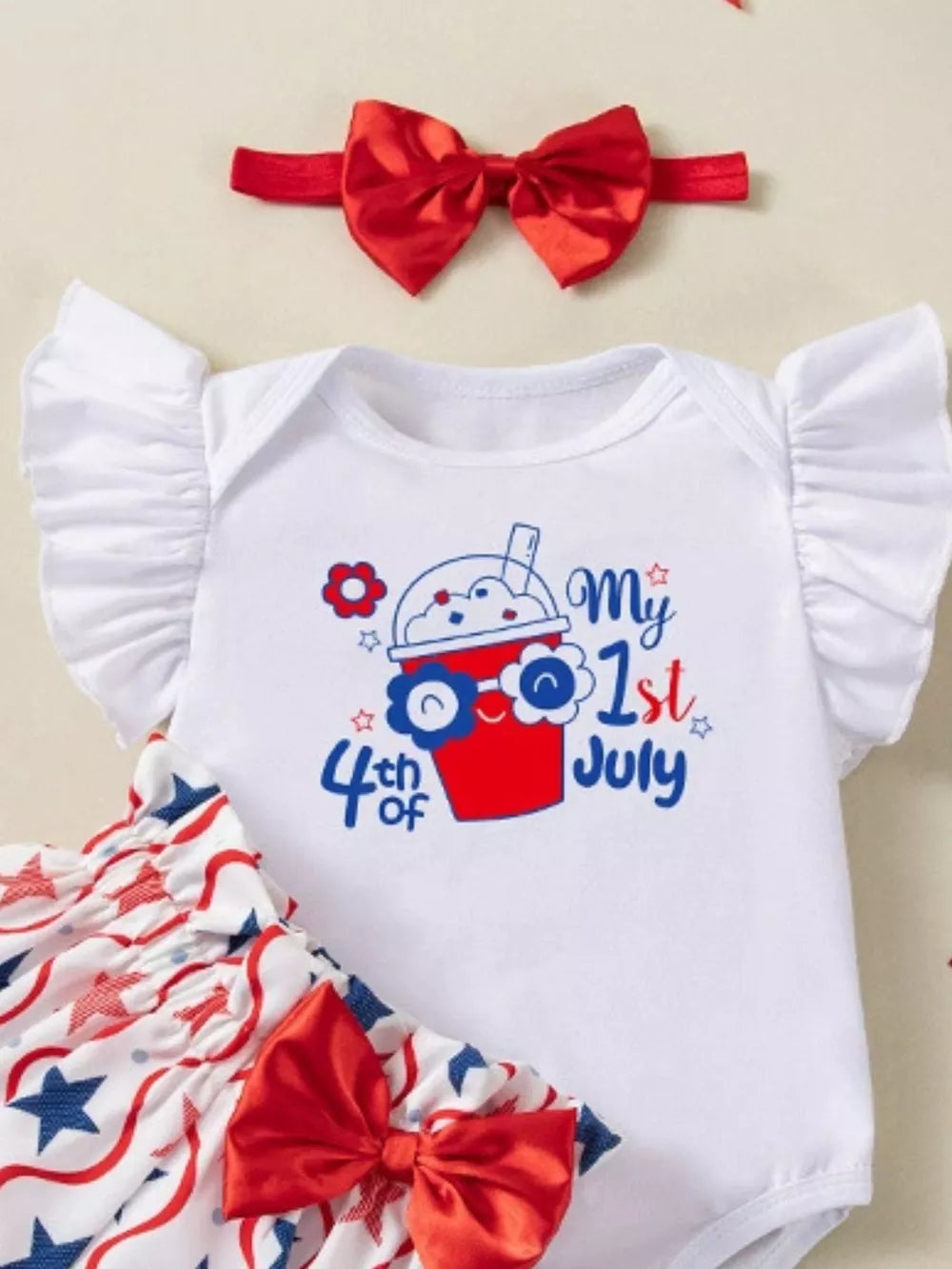 Baby 3-piece outfit set with white bodysuit, red star print bloomers, and red bow headband.
