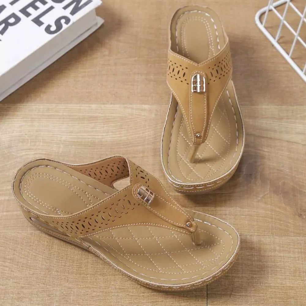 Khaki perforated leather thong wedge sandals with decorative buckle detail.