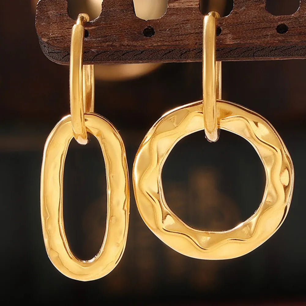 Textured gold vermeil hoop earrings with oval and wavy circular shapes.