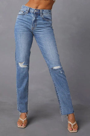 Distressed straight leg jeans in medium wash denim with ripped knees and frayed hem.
