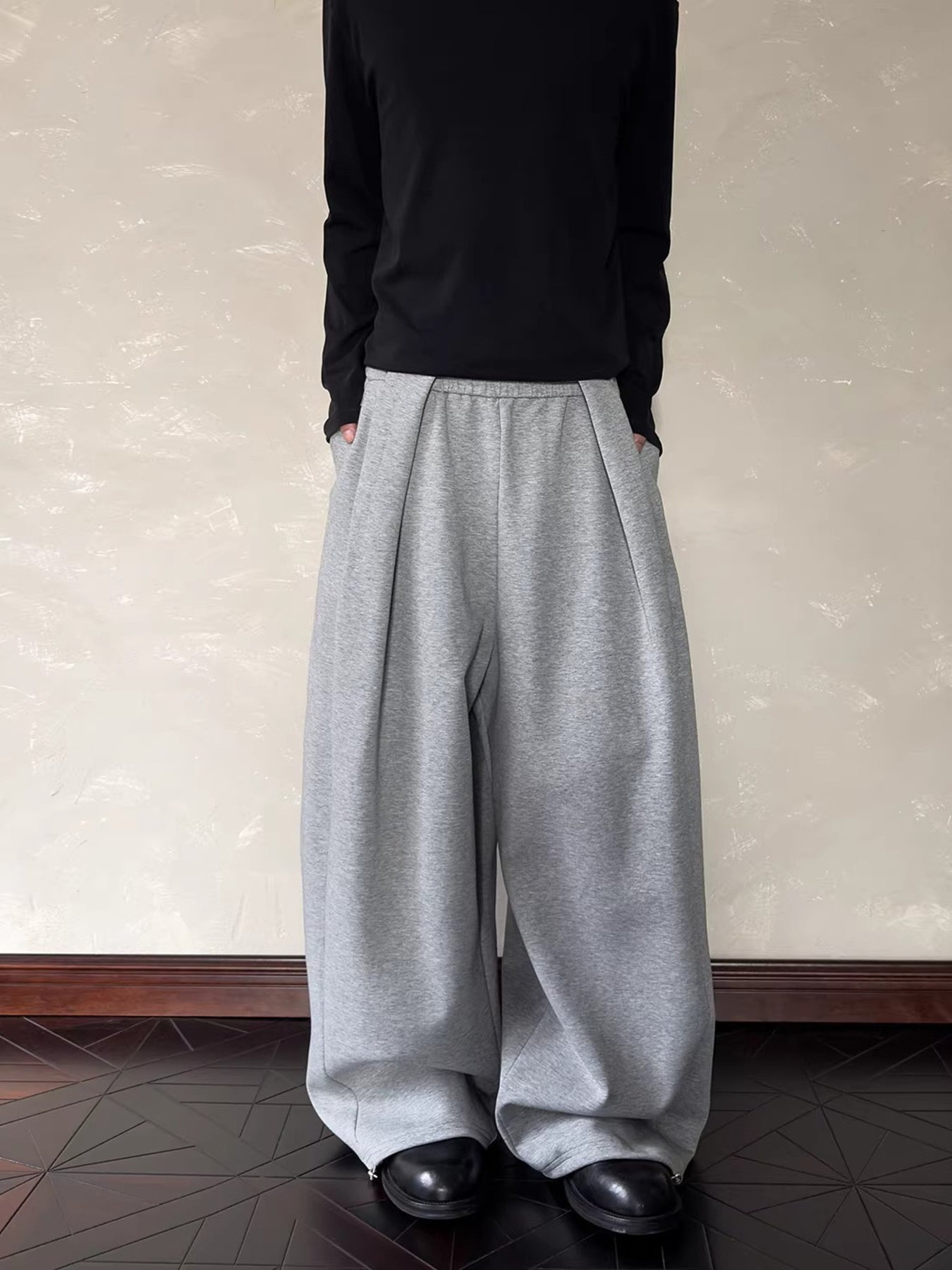 Men's grey relaxed fit sweatpants with elastic waist and pockets.