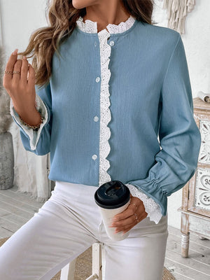 Light blue buttoned blouse with white lace trim on collar, placket, and ruffled cuffs.