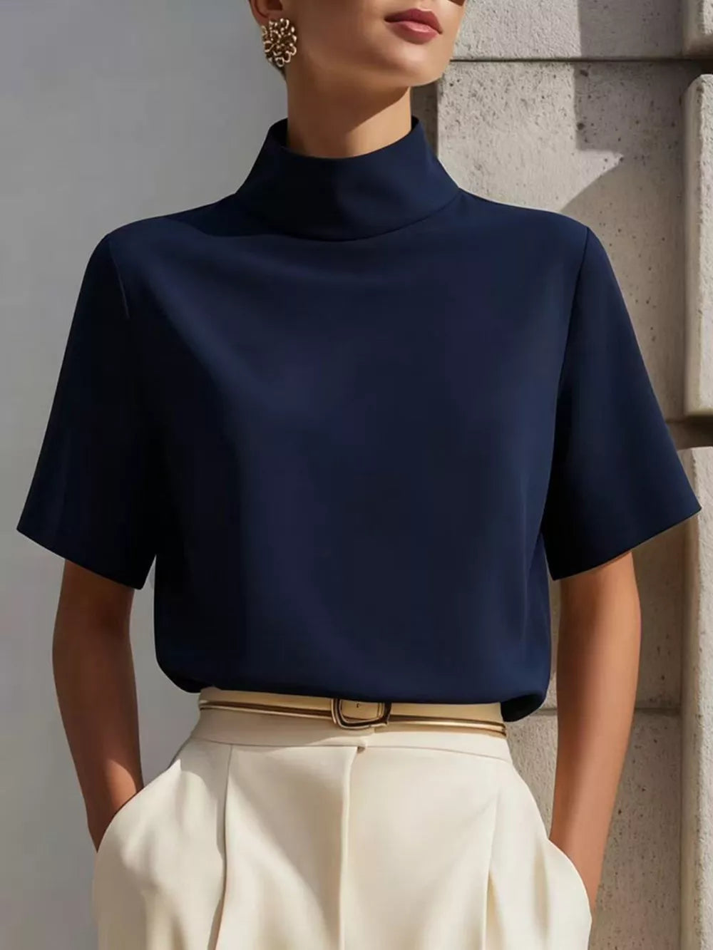 Navy mock neck t-shirt with relaxed sleeves and a polyester blend, styled with cream trousers.