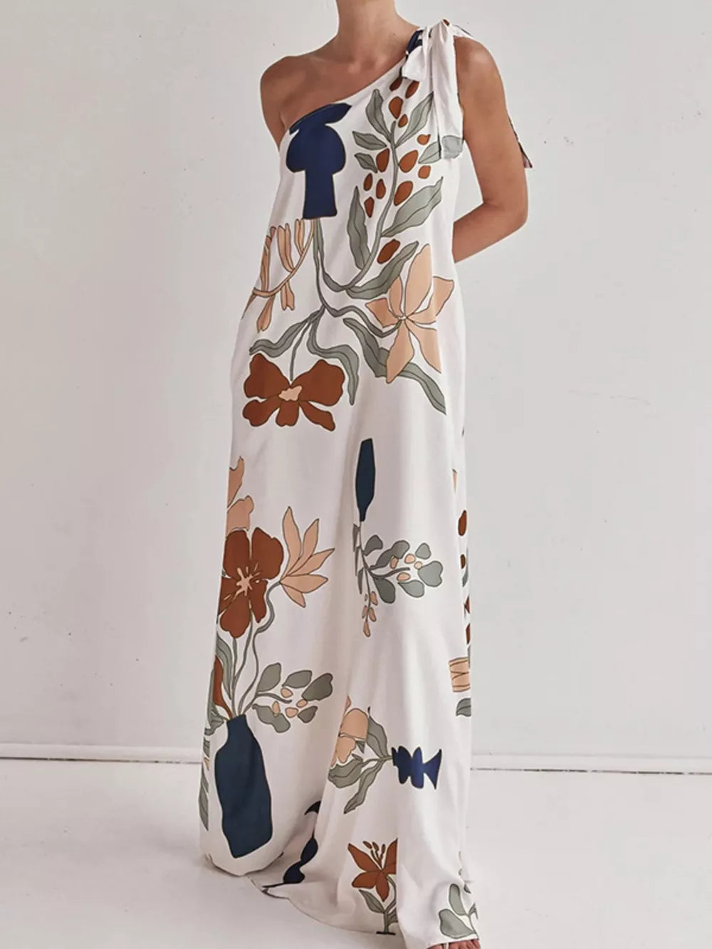 Elegant one-shoulder maxi dress with a bold floral print and tie detail.