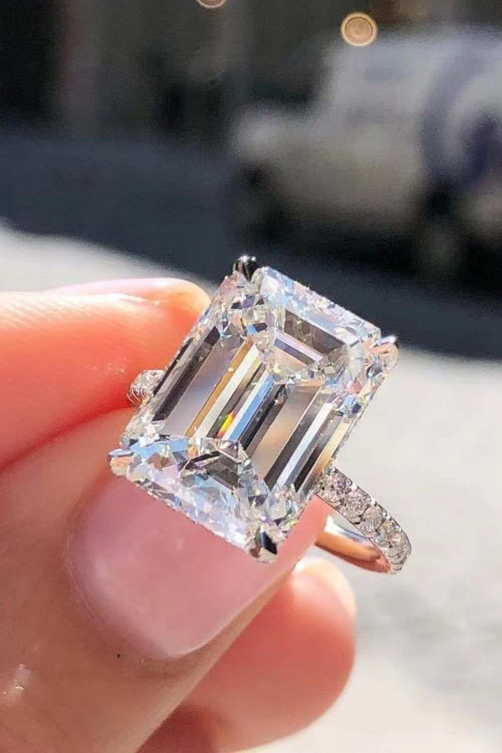 Sparkle Luxe Moissanite Halo Ring in silver with a large emerald-cut center stone and pavé band.