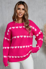 Hot pink knit pullover sweater with white heart stripe pattern, crew neck, long sleeves.