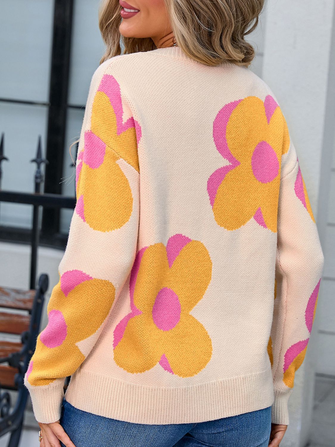 Ivory oversized knit sweater with large yellow and pink floral print.
