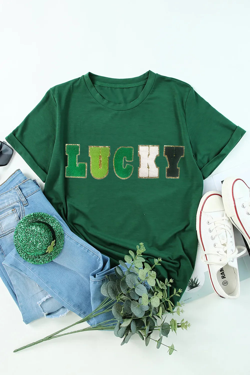 Dark green t-shirt with rolled sleeves and "LUCKY" appliqué in textured letters.
