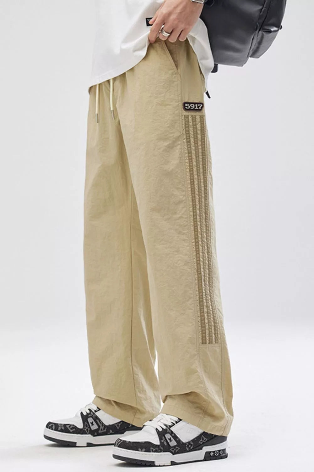 Khaki cargo pants with adjustable drawstring waist and side stripe detail.