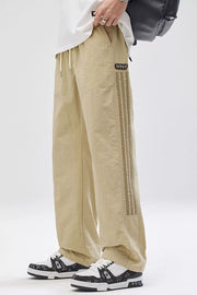 Khaki cargo pants with adjustable drawstring waist and side stripe detail.