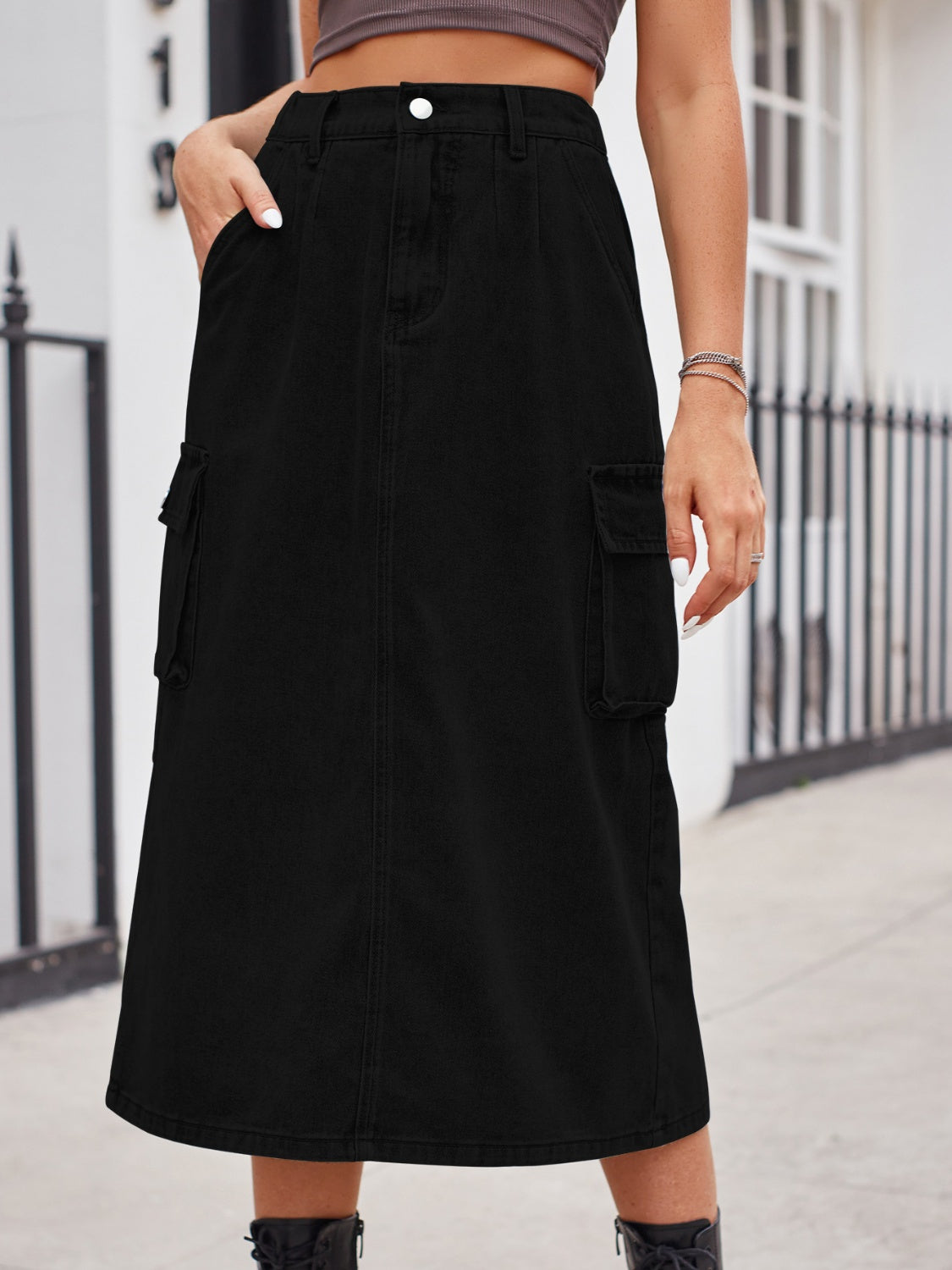 Black denim midi skirt with cargo pockets and a button closure.
