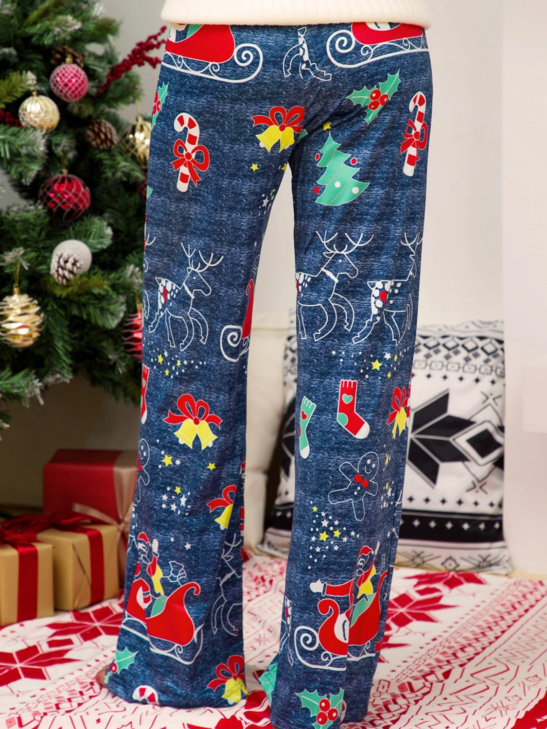 Festive print wide-leg lounge trousers in blue with Christmas motifs like reindeer, sleighs, and candy canes.