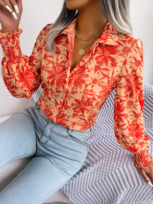 Floral print blouse in pumpkin with shirred cuffs and button front.