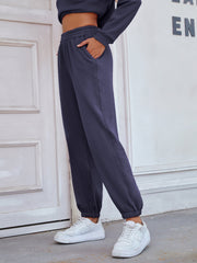 Dark blue relaxed fit joggers with elastic waistband and cuffed ankles.