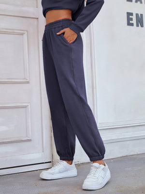 Dark blue relaxed fit joggers with elastic waistband and cuffed ankles.
