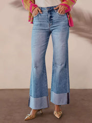 Distressed high-waisted flare jeans with raw hem and cuffed ankles in light wash denim.
