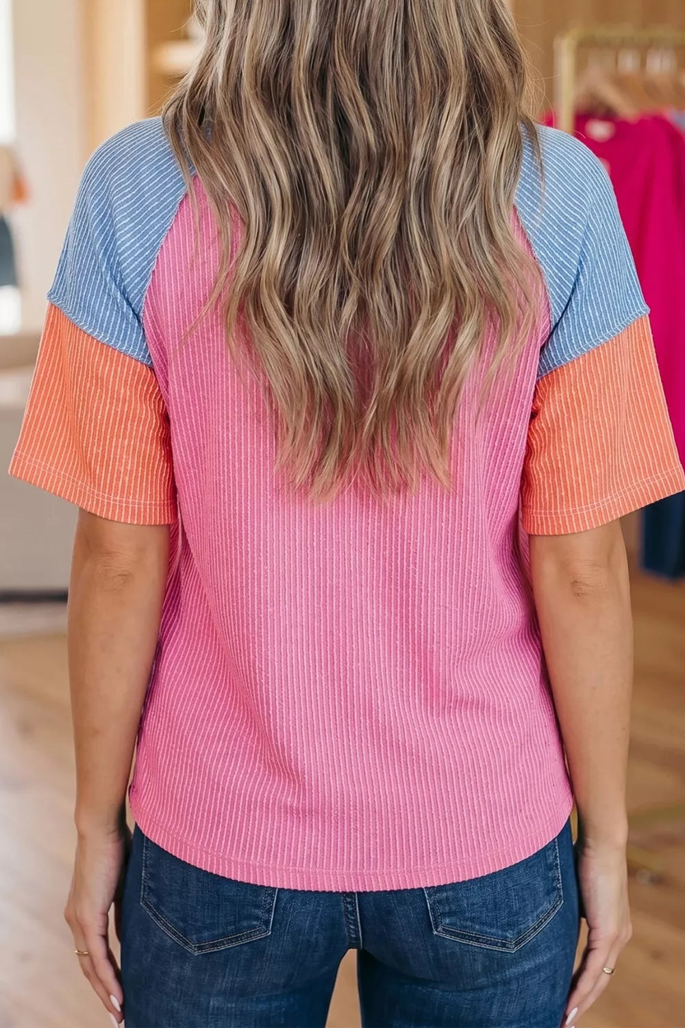 Ribbed t-shirt with color block sleeves in pink, orange, and blue.