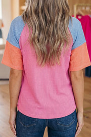 Ribbed t-shirt with color block sleeves in pink, orange, and blue.