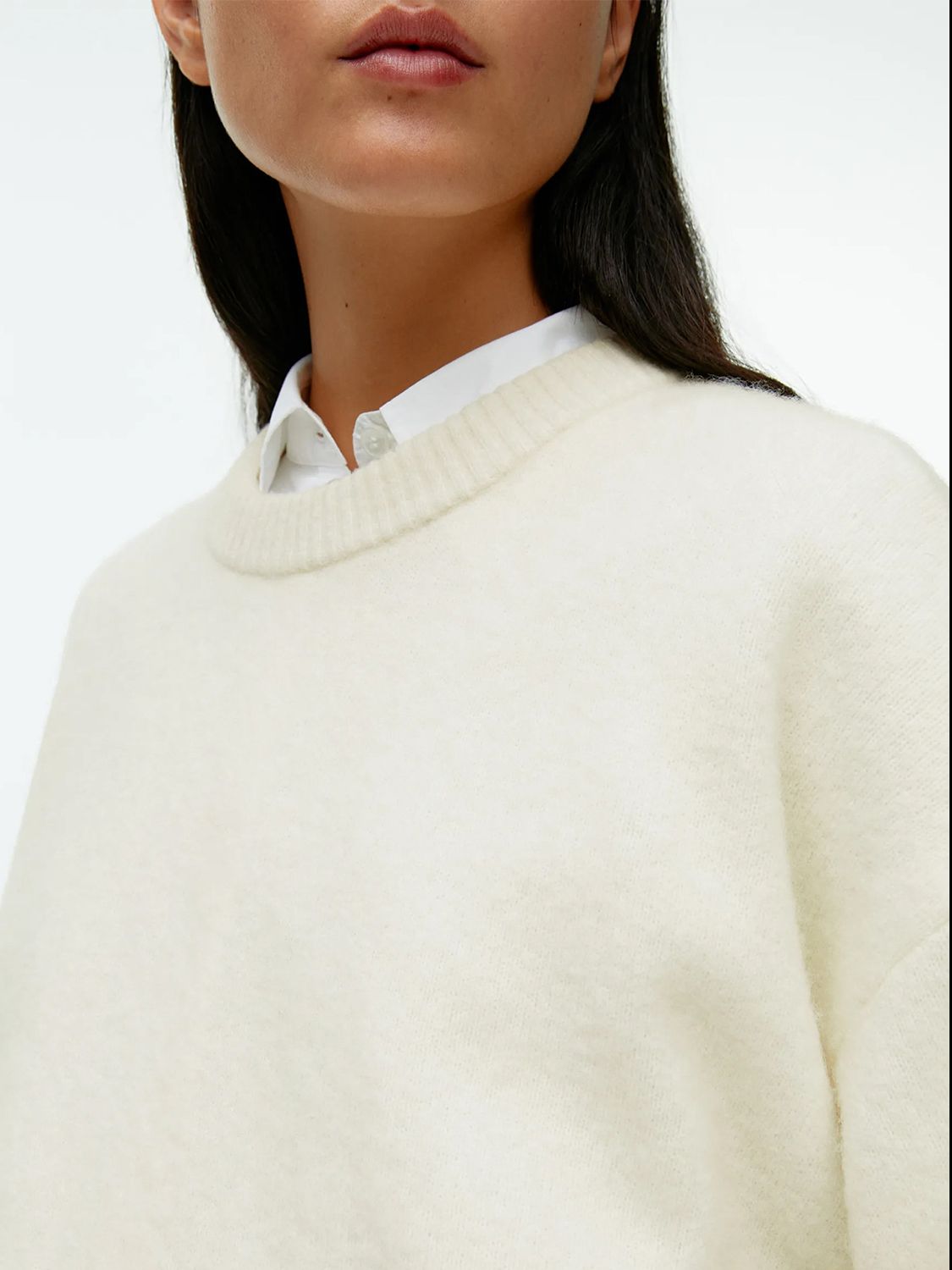Oversized ivory brushed knit crewneck sweater with ribbed collar, styled over a white shirt.
