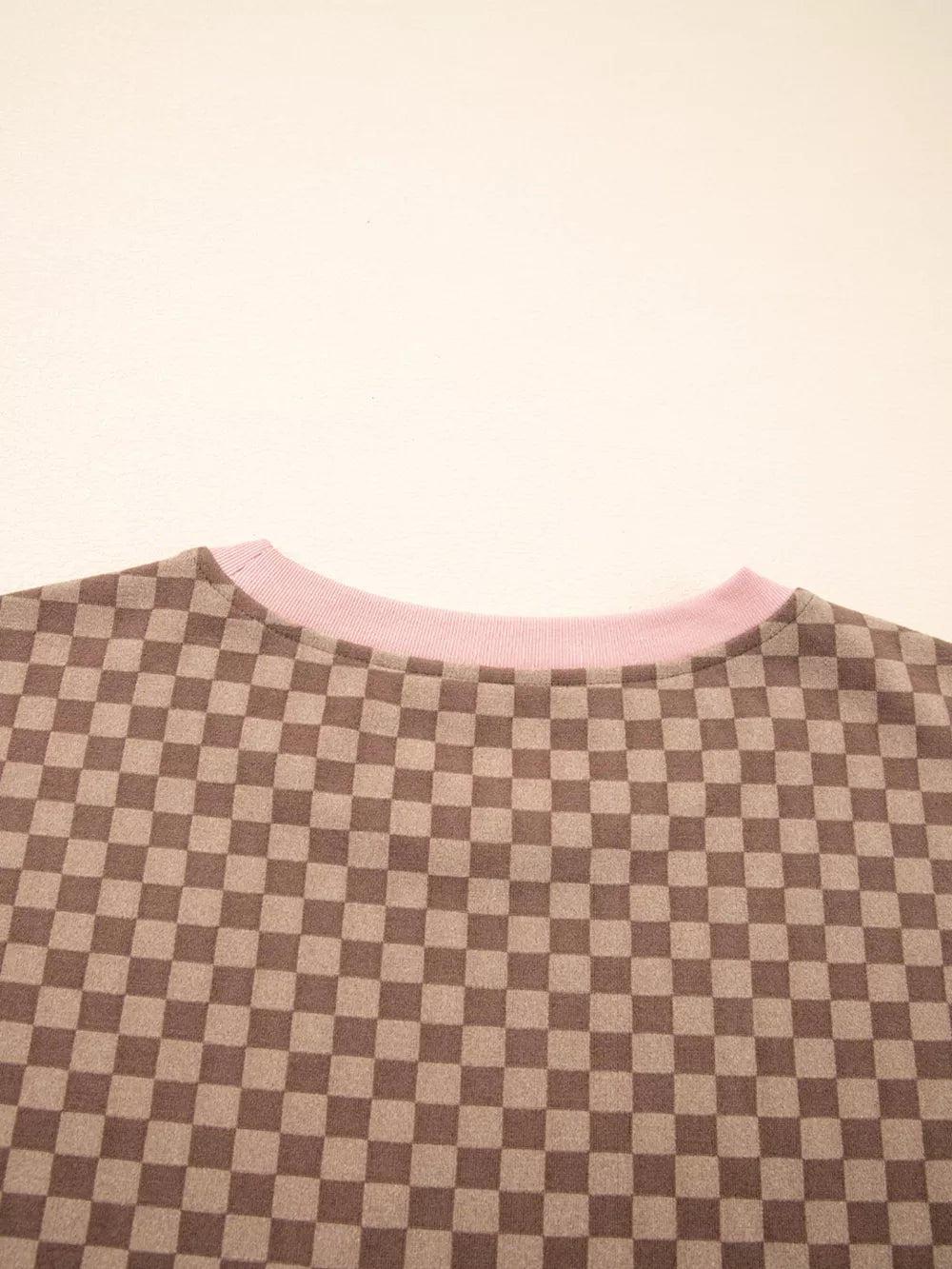 Chic checkerboard loungewear pullover with pink trim.