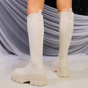 Off-white knit knee-high boots with chunky platform soles and pull tabs.