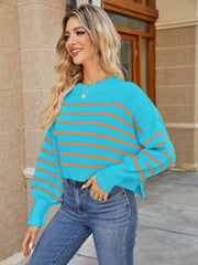 Cropped blue striped knit sweater with balloon sleeves and orange stripes.
