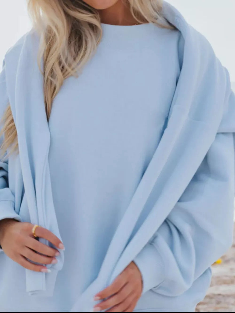 Sky blue crew neck sweatshirt with relaxed fit, soft material.