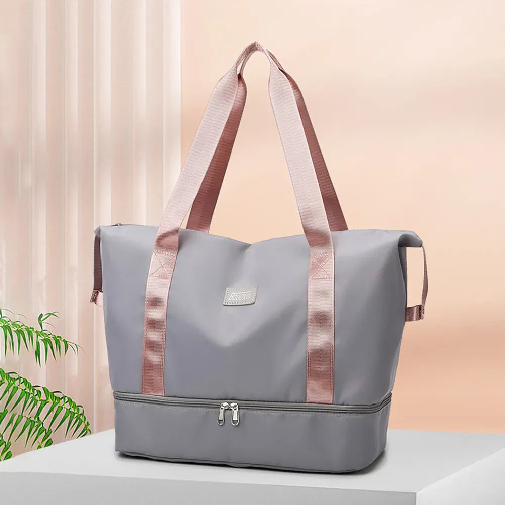 Gray dual-compartment travel tote with pink metallic trim and handles.