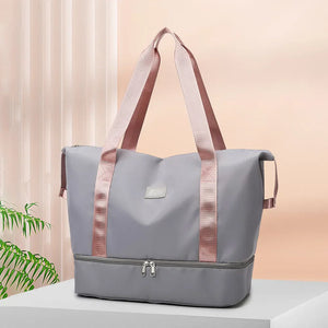 Gray dual-compartment travel tote with pink metallic trim and handles.