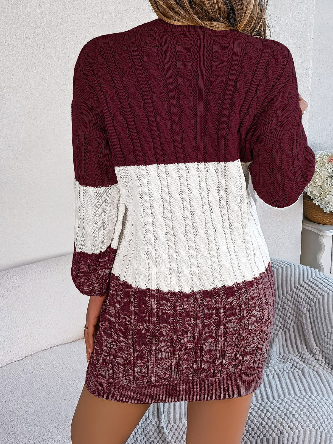 Colorblock cable knit mini dress in burgundy and white acrylic with long sleeves.