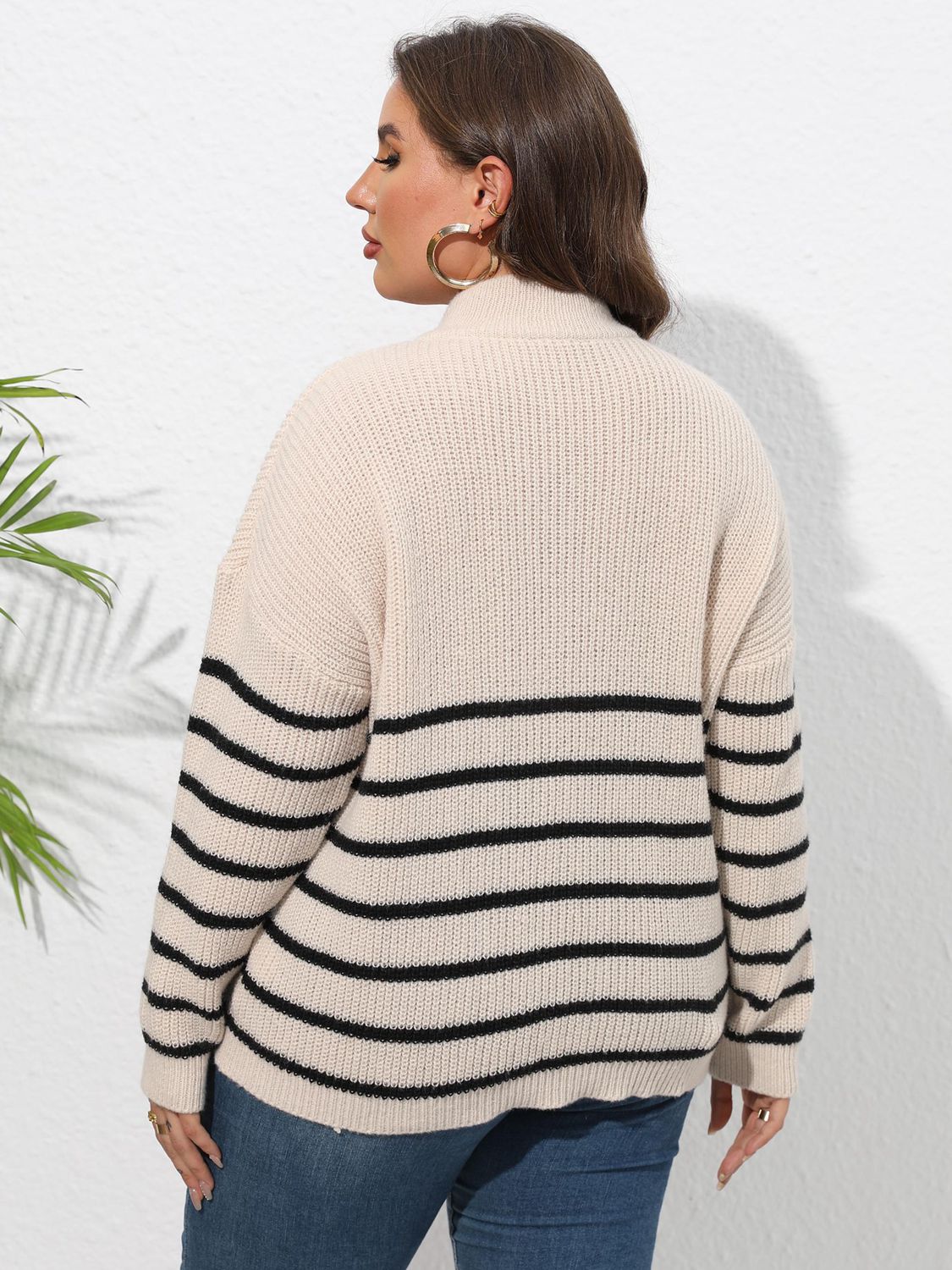 Beige ribbed knit sweater with black horizontal stripes and band collar.