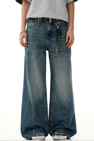 Men's relaxed fit jeans in vintage wash blue cotton, featuring a wide leg and distressed details.