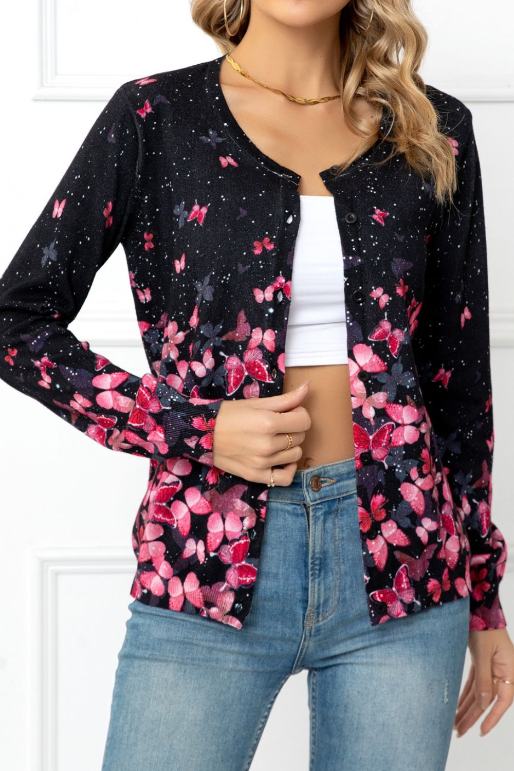 Black botanical print crewneck cardigan with pink butterflies and flowers, buttoned front.