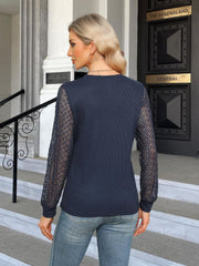 Dark blue waffle knit top with lattice sleeves and a crew neck.