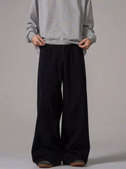 Black wide-leg sweatpants with pockets and a relaxed fit, styled with a grey sweatshirt.