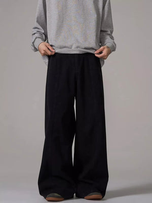 Black wide-leg sweatpants with pockets and a relaxed fit, styled with a grey sweatshirt.
