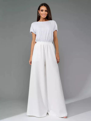 White wide-leg jumpsuit with shimmering sequin top and tie waist.