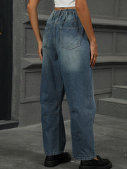 Relaxed fit medium wash denim trousers with elastic waistband and patchwork detail.