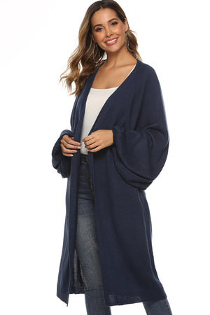 Dark blue oversized sleeve maxi knit cardigan with open front and side slits.