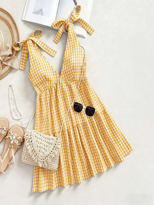 Yellow gingham mini dress with tie straps and tiered skirt.