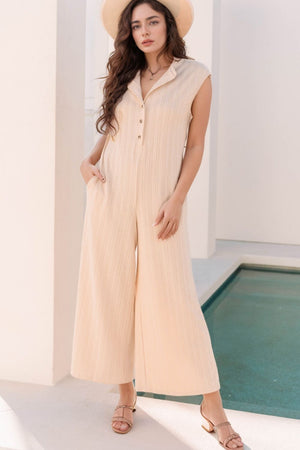Textured ribbed sleeveless collar jumpsuit in eggshell with button detail and wide legs.