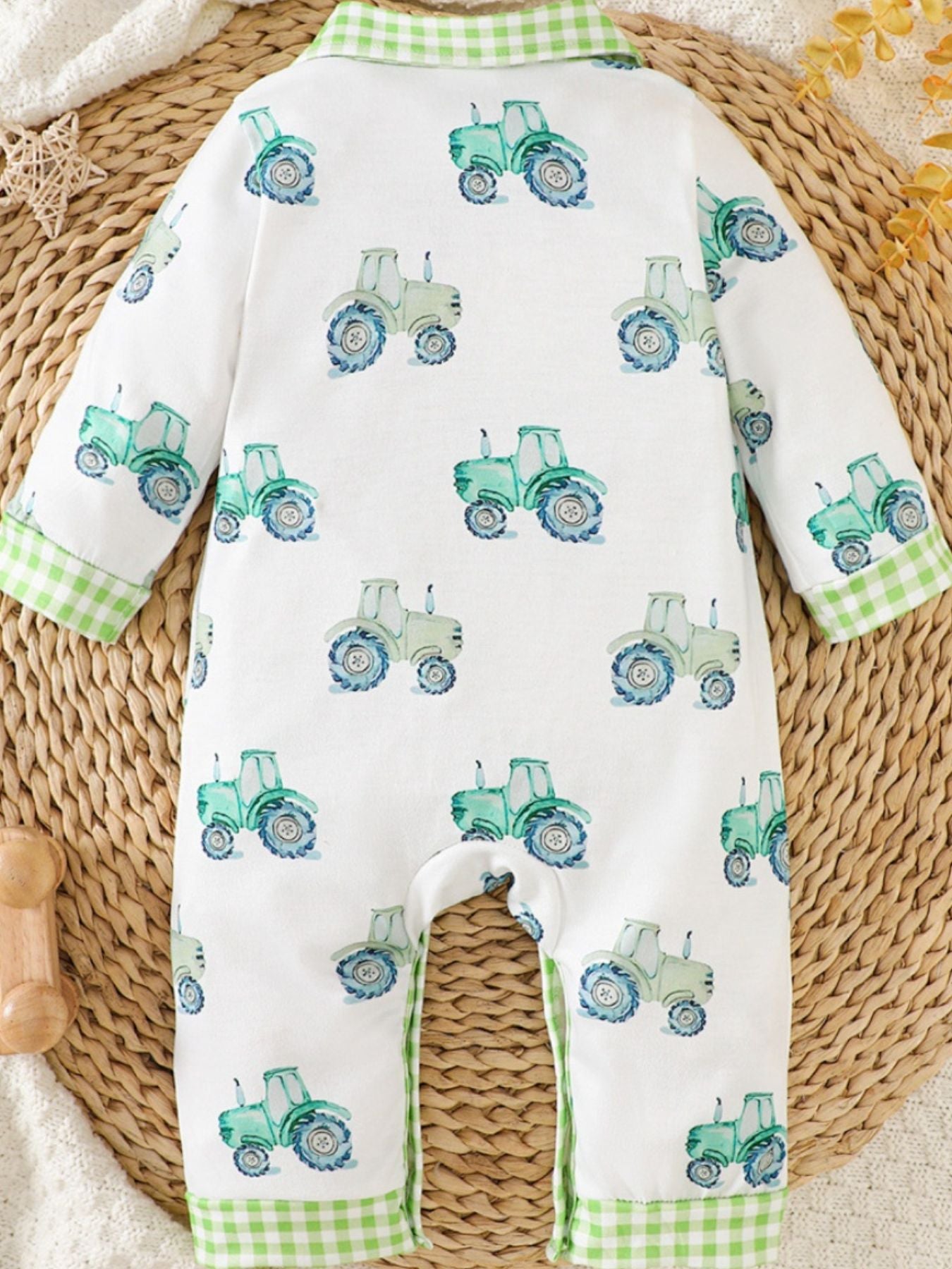 Baby one-piece with tractor print and green gingham trim.